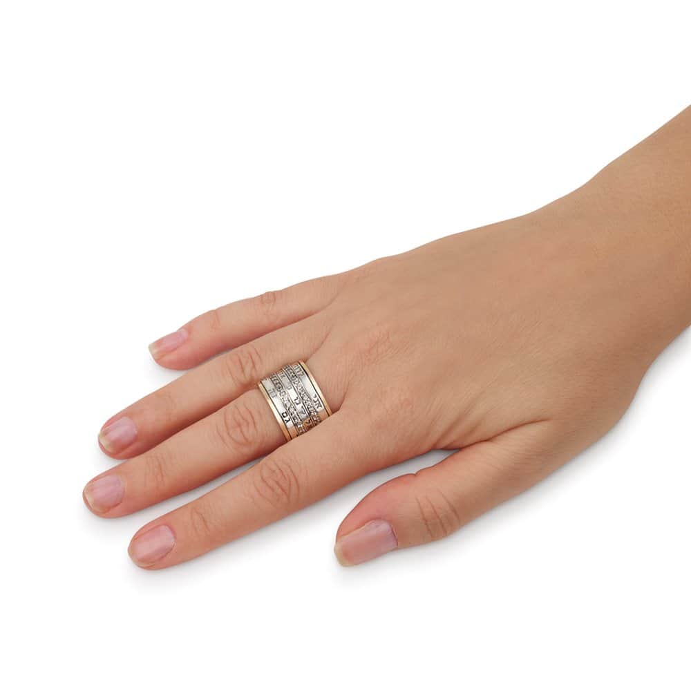 Woman wearing a bold 15 mm wide Hebrew blessing ring with layered silver and gold bands, engraved inscriptions and sparkling CZ stones
